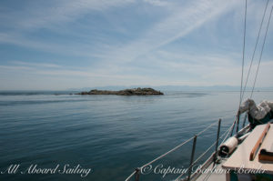 Sailing passed Whale Rocks in glassy waters